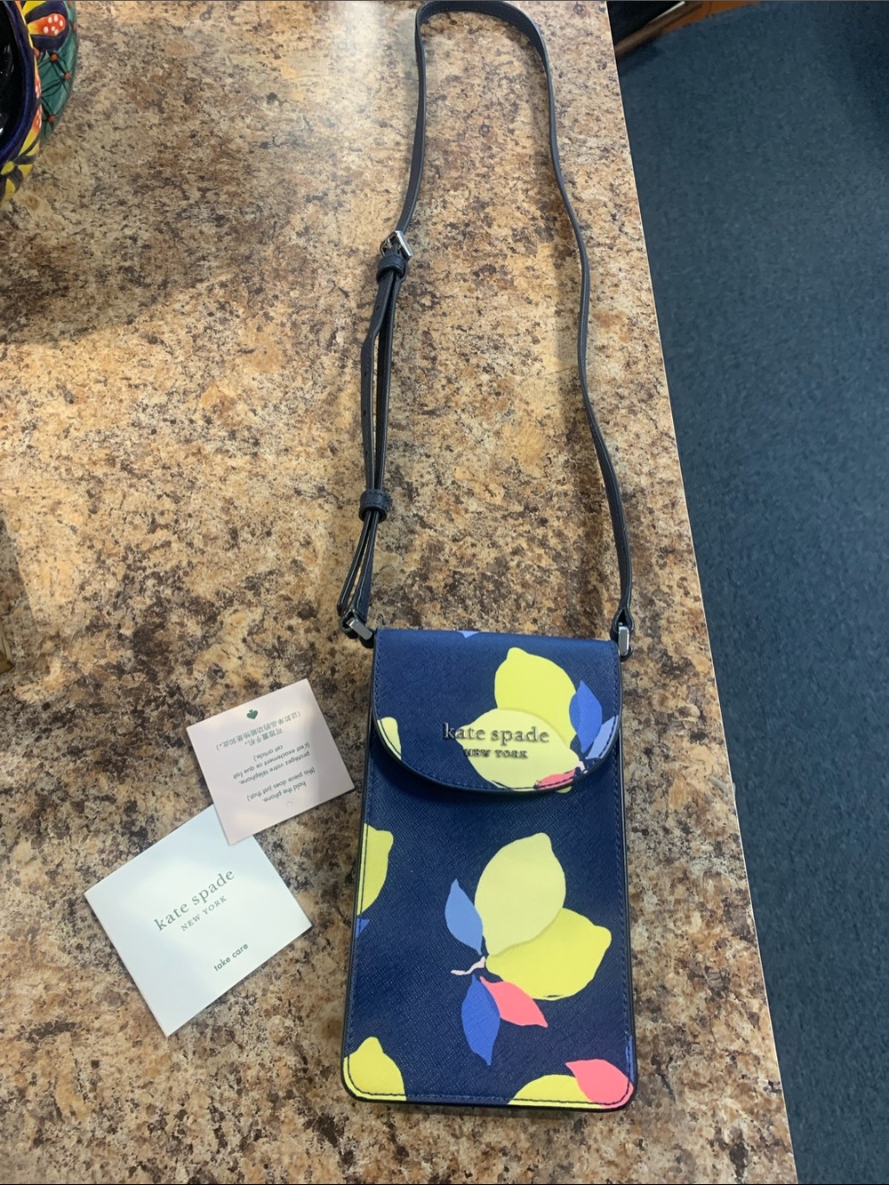 kate spade navy crossbody phone bag with yellow, pink and blue floral accents